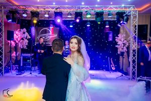 Wedding ballroom decorated with blue and purple lighting effects and dance floor setup.