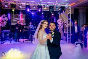 Wedding reception dance floor illuminated with vibrant purple and blue lighting effects.