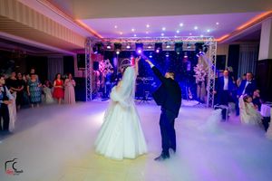 Elegant wedding reception space with professional lighting and atmospheric fog effects.