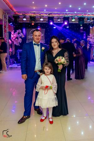 Wedding celebration in a grand ballroom with colorful lighting and formal attire.