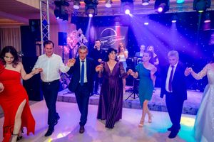 Elegant reception with dancers in formal wear under dramatic purple stage lighting and truss system.