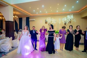 Wedding celebration in an elegant ballroom with crystal chandeliers and warm lighting.