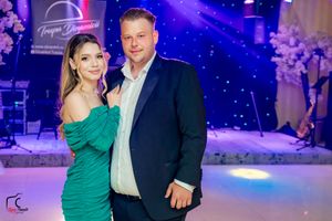 Dancers enjoying a formal evening event under vibrant blue and purple stage lighting.
