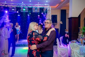 Evening dance party with couples moving across a beautifully lit ballroom floor.