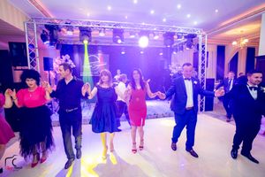 Wide view of a ballroom dance floor with purple lighting and entertainment setup.