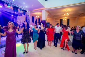Ballroom filled with dancers under theatrical lighting and professional sound equipment.
