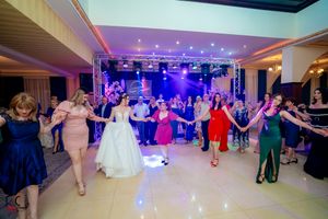 Reception celebration with dancers in colorful attire under stage lighting.