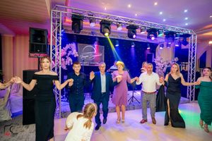 People enjoying group dance activities in a venue decorated with professional lighting and sound equipment.