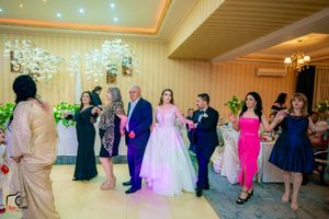 Event space decorated for a celebration with soft lighting and festive green decorations.