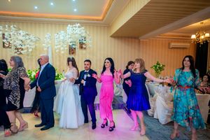 Wedding party and guests performing a coordinated dance routine in an elegant ballroom setting.