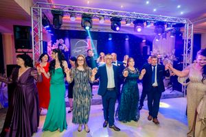Wide shot of wedding reception dance floor with guests performing synchronized moves.