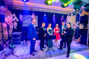 Elegant ballroom setup with colorful stage lighting and decorative elements for an evening celebration.