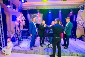 Dance floor and seating area bathed in blue and purple lighting effects at an indoor event.