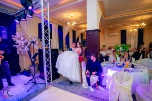 Wedding venue with professional lighting setup and elegant white decor elements.