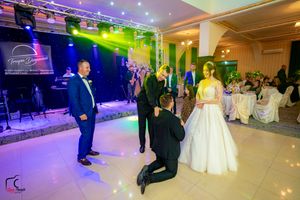 Ballroom celebration with purple and green ambient lighting creating a festive atmosphere.