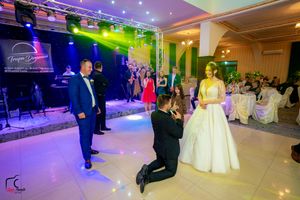 Elegant wedding reception with dynamic lighting effects and guests celebrating on the dance floor.