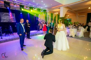 Modern wedding reception hall with atmospheric lighting and guests mingling on the dance floor.