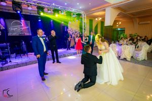 Elegant ballroom setup with dramatic lighting effects and guests dancing at a wedding celebration.