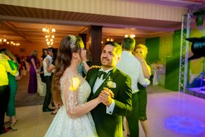 Wedding reception dance floor with purple and green ambient lighting creating a festive atmosphere.