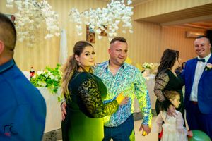 Wedding reception venue decorated with hanging lights and floral arrangements during evening celebrations.