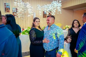 Wedding party dancing and mingling under elegant chandeliers and ambient lighting.