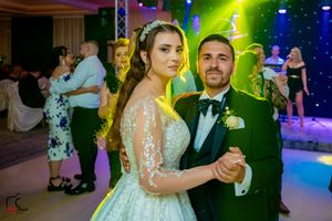 Wedding reception dance floor illuminated by colorful stage lighting and decorative elements.