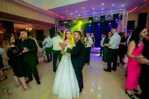 Reception venue with starlit ceiling and colorful lighting effects during dance festivities.