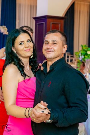 Couples dancing at a formal event with bright pink and black attire.