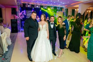 Wedding reception dance floor with guests dancing under colorful lighting.