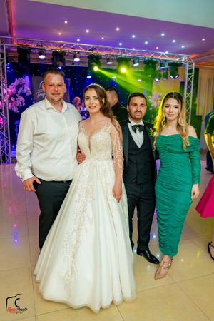 Wedding celebration with bride in white gown and guests on dance floor.