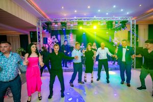 Panoramic view of a wedding reception dance floor with colorful lighting effects.