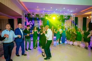 Dance participants following choreography in a line formation with vibrant blue and green lighting effects.