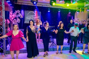 Group dance participants following steps in formation with theatrical lighting effects.