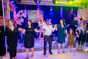 Line dance class performing coordinated moves under colorful venue lighting.