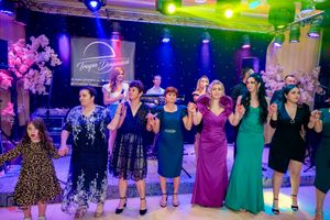 Social dancers in formation moving together during group dance routine with colorful lighting.