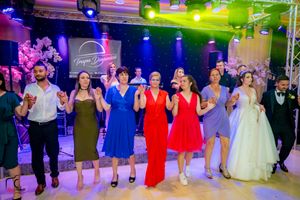 Wedding celebration featuring coordinated group dance with colorful lighting and elegant venue setup.
