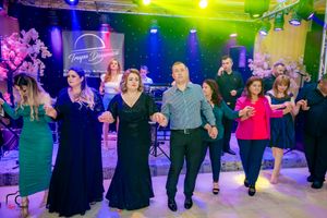 Festive reception gathering with guests participating in synchronized dance under colorful lighting effects.
