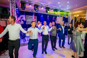 Ballroom dance event with couples moving across a brightly lit dance floor under professional lighting.