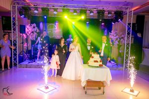 Wedding venue with sparkler effects illuminating the dance floor and cake presentation.