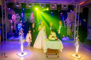 Panoramic shot of wedding reception showing dance floor, cake, and dramatic lighting effects.
