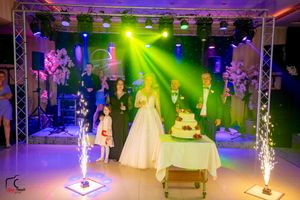 Wedding celebration space with dramatic lighting and pyrotechnic effects near the cake display.