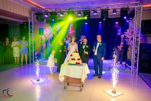 Wedding venue with professional lighting trusses creating a dynamic atmosphere with purple and green hues.