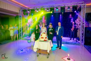 Wedding venue featuring professional lighting trusses and special effects in purple and green tones.