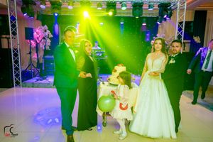 Wedding celebration with dramatic green and purple lighting effects in an elegant reception venue.