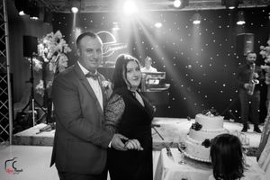 Wedding reception dance floor with colorful lighting and guests dancing in an elegant ballroom setting.
