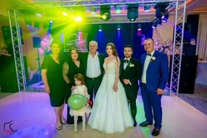 Panoramic view of a wedding celebration with stage lighting and formal attire.