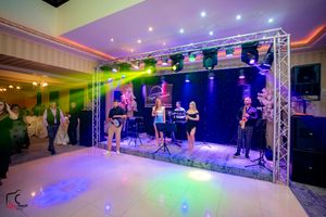 Wide angle shot of an illuminated dance floor with purple and green lighting effects.