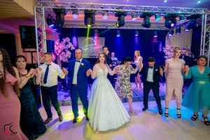 Wedding celebration with guests performing coordinated dance moves in an elegant venue.