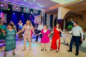 Panoramic shot of dancers performing coordinated moves in a ballroom with professional lighting setup.