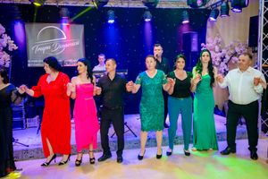 Group dance routine with performers in coordinated colors on decorated stage.